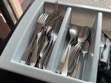 a tray with silverware in it on a table