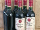 four bottles of wine are lined up on a wooden shelf