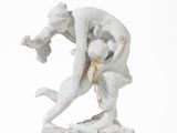 une statue représentant un homme aux prises avec une femme, posée sur une surface blanche