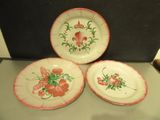 three plates with flowers on them on a table