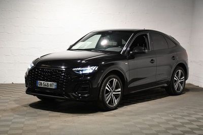 L'Audi QX est garée dans un garage dont le sol est en damier.