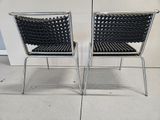 pair of chrome and black woven chairs on a white tiled floor