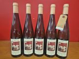 six bouteilles de vin sont alignées sur une table