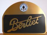 une enseigne dorée et noire surmontée d'une horloge