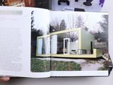 someone is holding a book open to a picture of a house