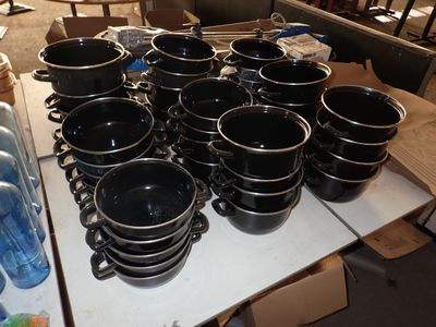 une table sur laquelle se trouvent de nombreuses tasses noires