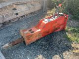 a red bulldozer sitting on the ground next to a pile of rocks
