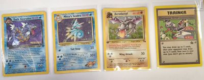 four different pokemon cards are lined up on a white surface