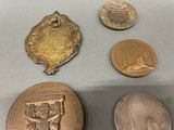 three coins and a medal are sitting on a table