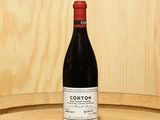 a bottle of wine sitting on top of a barrel