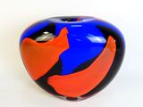 a blue and orange vase sitting on a white surface