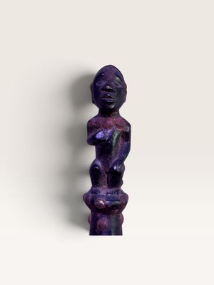 une image représentant une statue violette posée sur une surface blanche