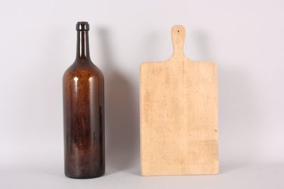 a wooden cutting board next to a bottle of wine