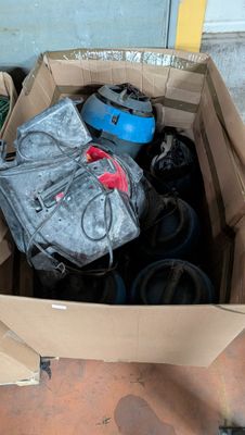 une boîte en carton remplie d'objets divers, posée par terre