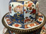 un grand vase muni d'un couvercle, posé sur une table