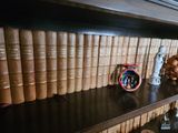 a shelf full of books and a clock on it