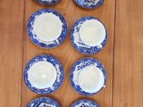 six blue and white china cups and saucers on a wooden table