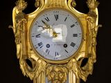 a gold clock hanging on the wall in the room