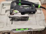 a corded jig saw and two other tools on the table