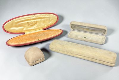 trois valises et un chapeau posés sur une surface blanche
