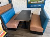 a booth with two benches and a table with a laptop on it