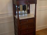 une petite armoire en bois surmontée d'un miroir