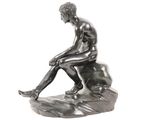 a statue of a man sitting on top of a rock