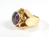 une image d'une bague en or avec une pierre violette au centre