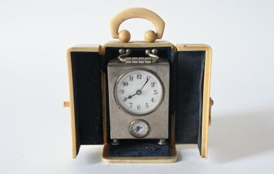 a small clock inside of a case on a white surface