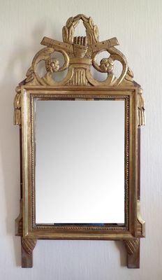 un miroir accroché au mur avec un cadre doré