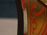 a close up of a clock with a red and gold design