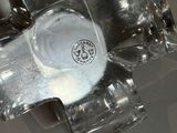 a glass cross on a table with a cup on it