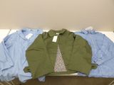 three pairs of shirts are sitting on a table in a room