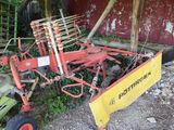 a red tractor with a yellow plow attached to it