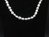 un collier de perles blanches sur un mannequin noir