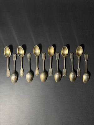 six spoons are lined up in a row on a black surface