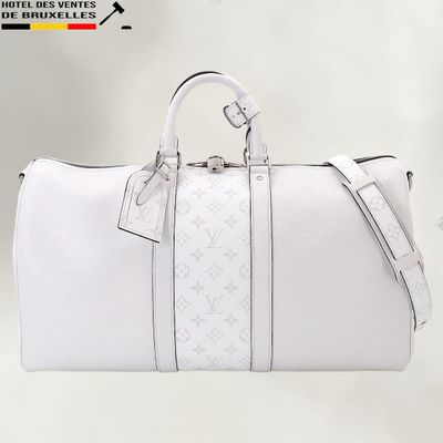 un sac Louis Vuitton blanc posé sur une table