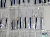 many toothbrushes and toothpaste in bags on the wall