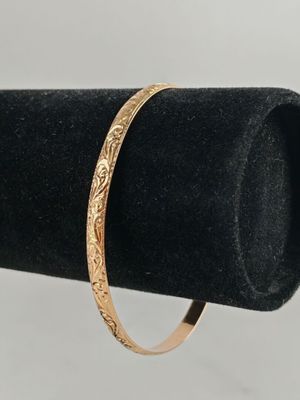 a close up of a gold bracelet on a black ring holder