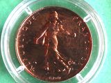 a close up of a coin in a plastic container on a green surface