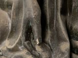 close up of a statue of a person ' s feet and hands