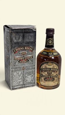 une bouteille de whisky Chivas Regal posée à côté d'une boîte sur une table