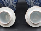 two blue and white vases sitting on a table