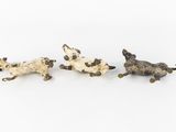 three small figurines of dogs on a white background