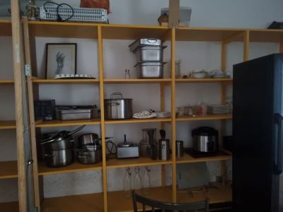 a kitchen with a table and a refrigerator in it