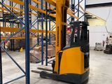 a forklift in a large warehouse with lots of pallets