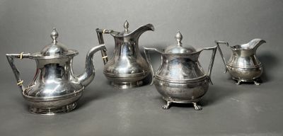 three silver teapots and a coffee pot on a table