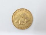 a close up of a gold coin on a white surface