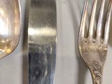 two forks and a spoon sitting on a table