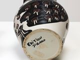 a black and white vase sitting on a white table